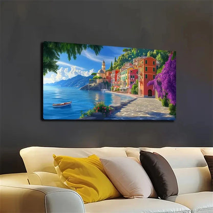 Canvas print of a coastal scene with buildings and a boat, hanging on a dark wall above a sofa.