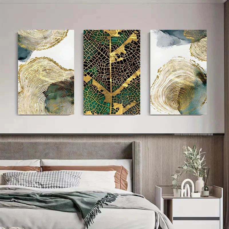 Three abstract art pieces on a wall above a bed
