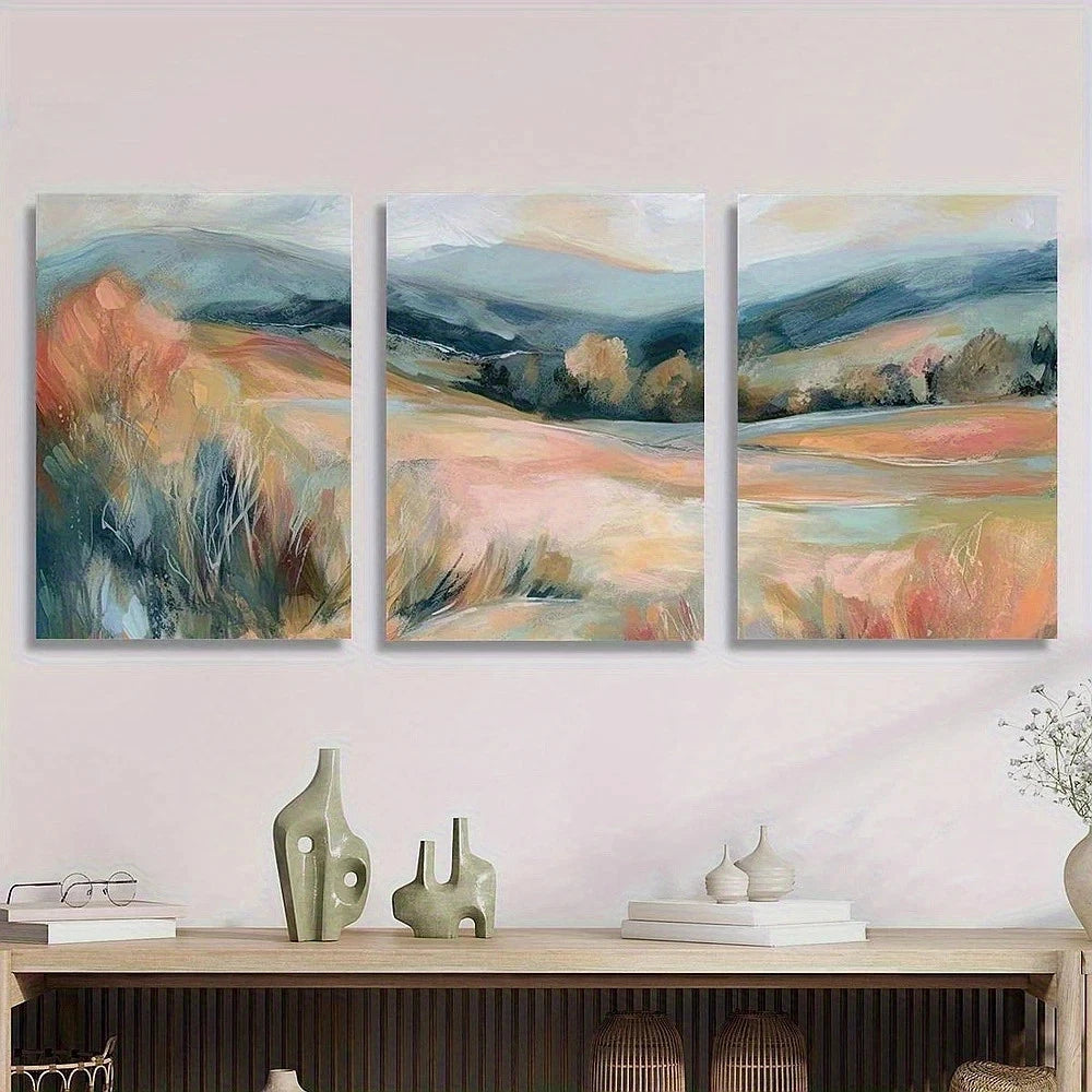 Three abstract landscape paintings on a wall above a wooden console table with decorative items.