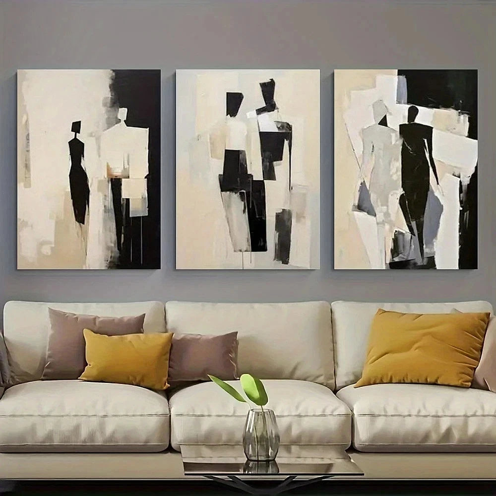 Three abstract art pieces on a wall above a beige sofa with colorful cushions.