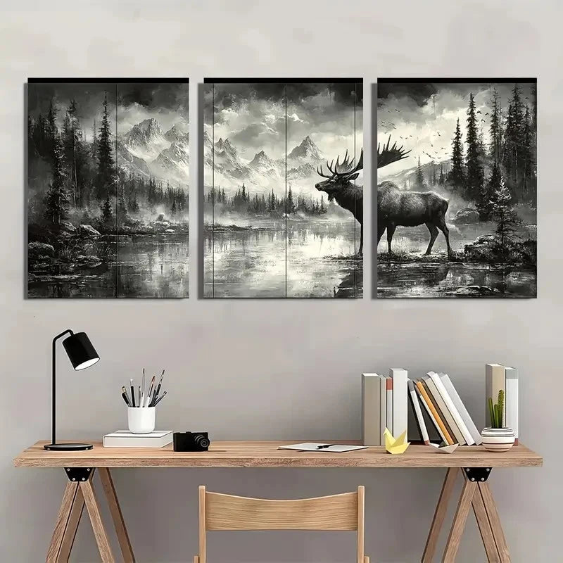 Three-panel wall art of a moose in a forest setting above a wooden desk with books and a lamp.