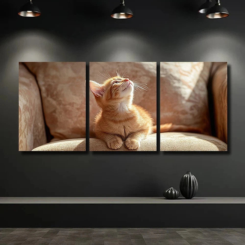 Triptych wall art of a kitten on a couch with a dark background