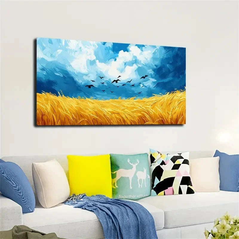 Canvas print of a landscape with a blue sky, yellow field, and birds, hanging above a sofa with colorful pillows.