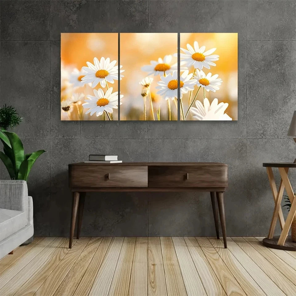 Three-panel wall art of daisies on a gray wall with a wooden console table below.