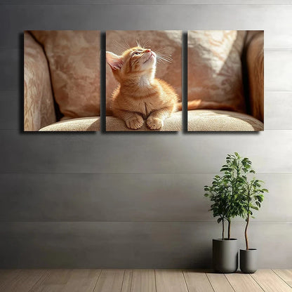 Triptych wall art of a cat on a couch with plants on the floor.