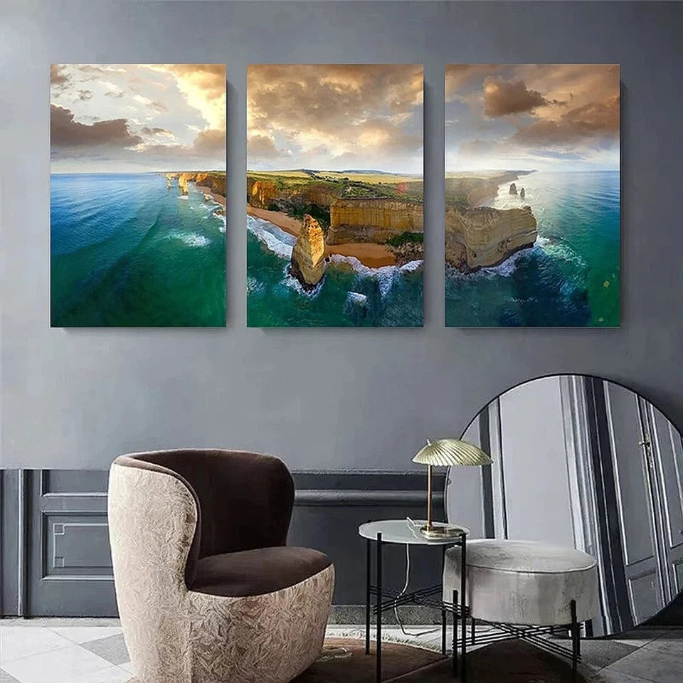 Three-panel wall art of a coastal landscape above a modern living room setup.