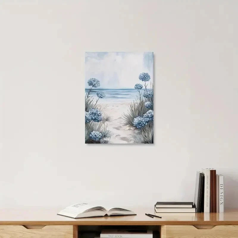 Art print of a beach scene with flowers on a wall above a wooden shelf with books.